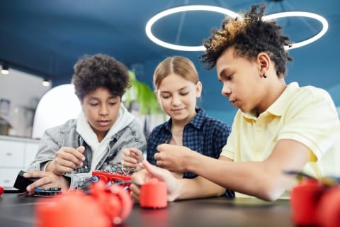 Three students working on a project hand-on